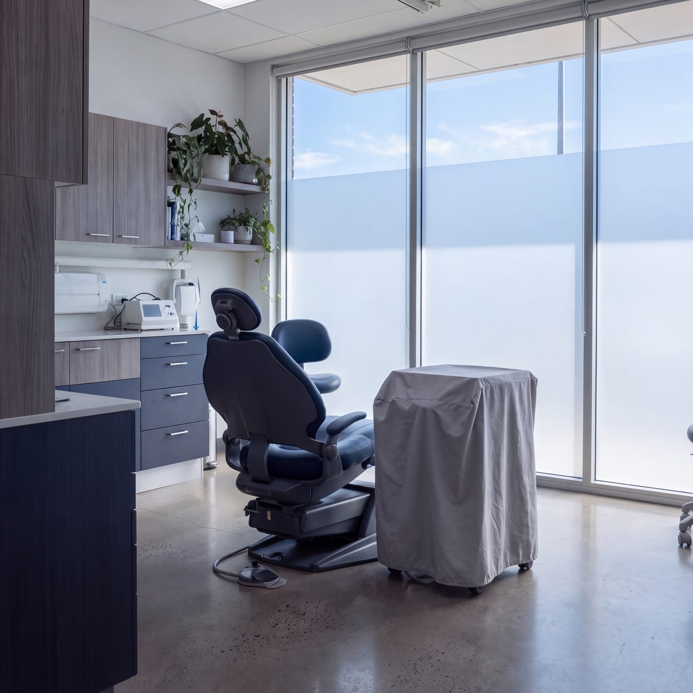 Dental surgery with a treatment chair and instrument bench beside a window